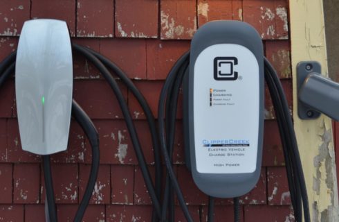 Close up view of an electric vehicle charge station secured to the side of a house